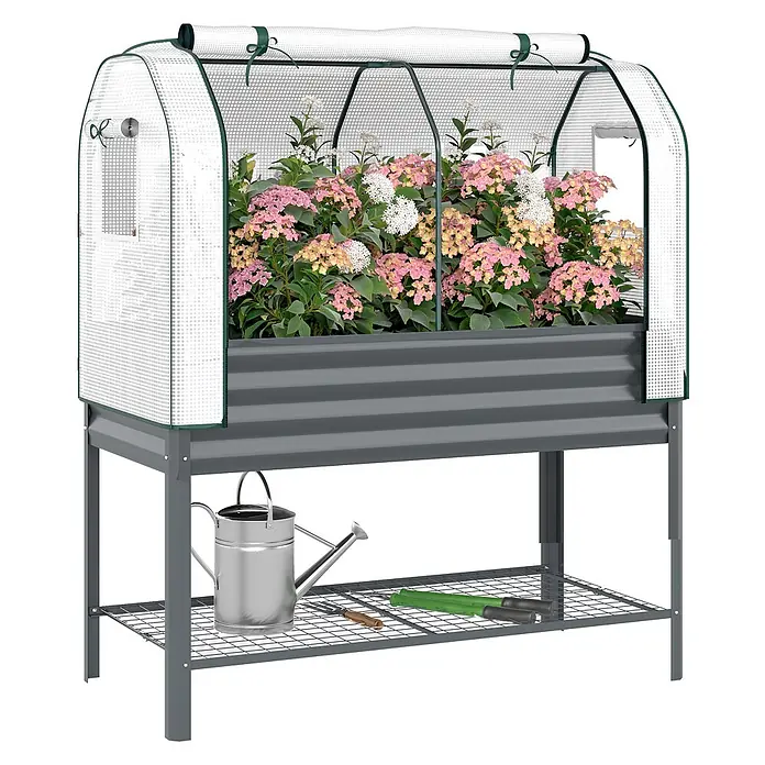 Outsunny Hochbeet Mit Frühbeetaufsatz - Metall, Dunkelgrau - Graues Hochbeet aus Metall mit weißer, halbtransparenter Gewächshausabdeckung, bepflanzt mit Hortensien, und einer Ablage für Gartenwerkzeuge.