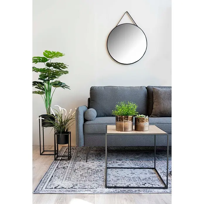 Tinkaro Übertopf rund Blumentopfständer - Außenmaß (Ø x H): 19,5 x 50,5 cm, schwarz, Stahl - Ein modernes Wohnzimmer mit grauem Sofa, gemustertem Teppich, quadratischem Couchtisch, Topfpflanzen und einem runden Spiegel an der Wand.