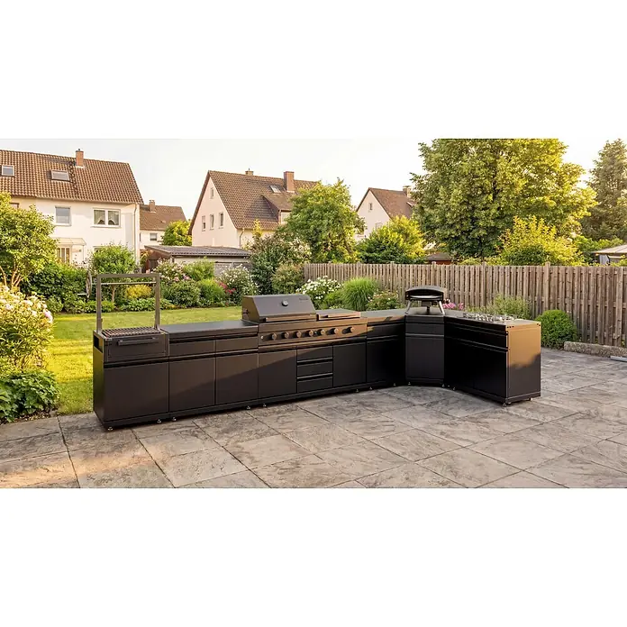 Kingstone Cube Outdoorküche - 7 -tlg., Stahl, Sintered Stone, Schwarz, Material Grillfläche: Gusseisen, Anzahl Brenner: 11 Stk. - L-förmige Outdoor-Küche aus dunklem Metall mit Grill, Pizzaofen und Kochfeld auf einer Terrasse.