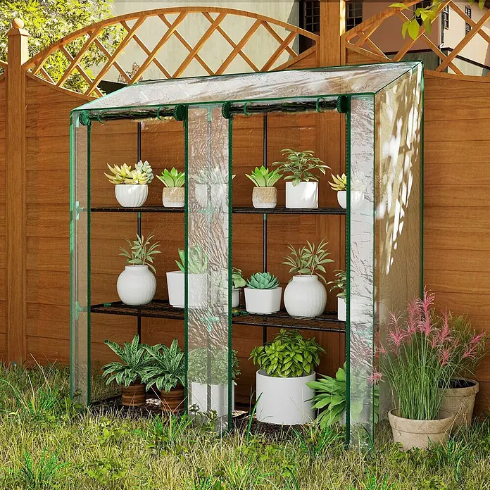 Outsunny Gewächshaus - 143 x 46 cm, Material Seitenwand: Kunststoff, 0,3 mm, Schwarz - Kleines, transparentes Gewächshaus mit grünem Rahmen, gefüllt mit Topfpflanzen, im Garten neben einem Holzzaun.