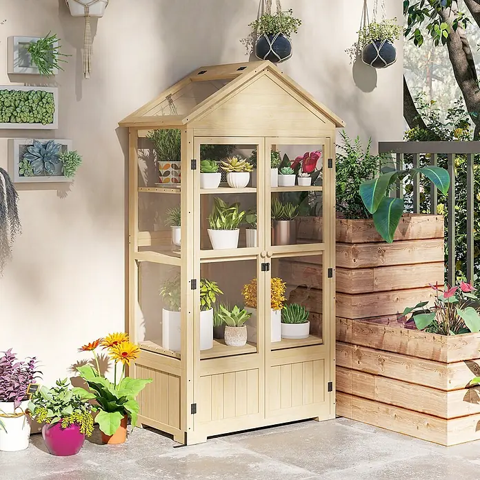 Outsunny Gewächshaus - Außenmaß inkl. Dachüberstand (B x T): 100 x 56,5 cm, Material Seitenwand: Kunststoff, 0,8 mm, Naturholz - Kleines Gewächshaus aus hellem Holz mit Glaspaneelen, das verschiedene Topfpflanzen auf einer Terrasse zeigt.
