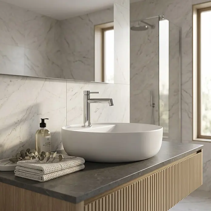GME Grifo de lavabo Persio - Cromo, Brillante - Mueble de baño moderno con lavabo sobre encimera blanco, grifo cromado y base de lamas de madera. Jabón y toallas sobre la encimera oscura.