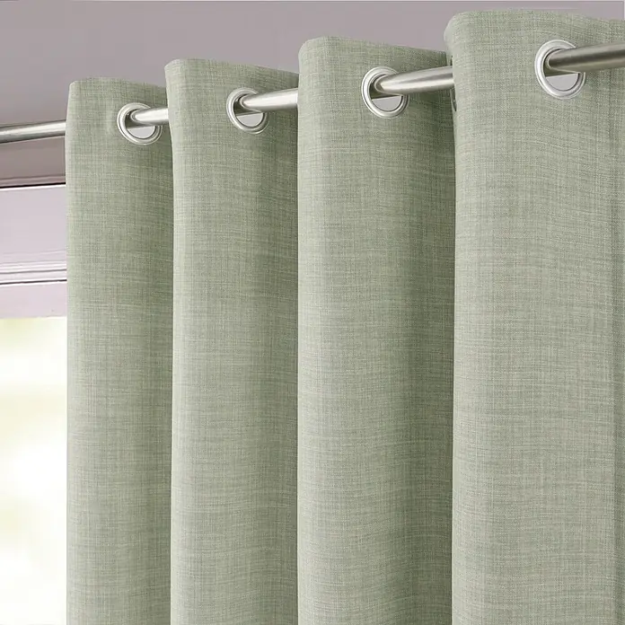 Cortina con ollaos opaca Novan - An x Al: 140 x 260 cm, Verde Sage - Cortinas de ollaos verde salvia texturizadas colgadas de una barra plateada.