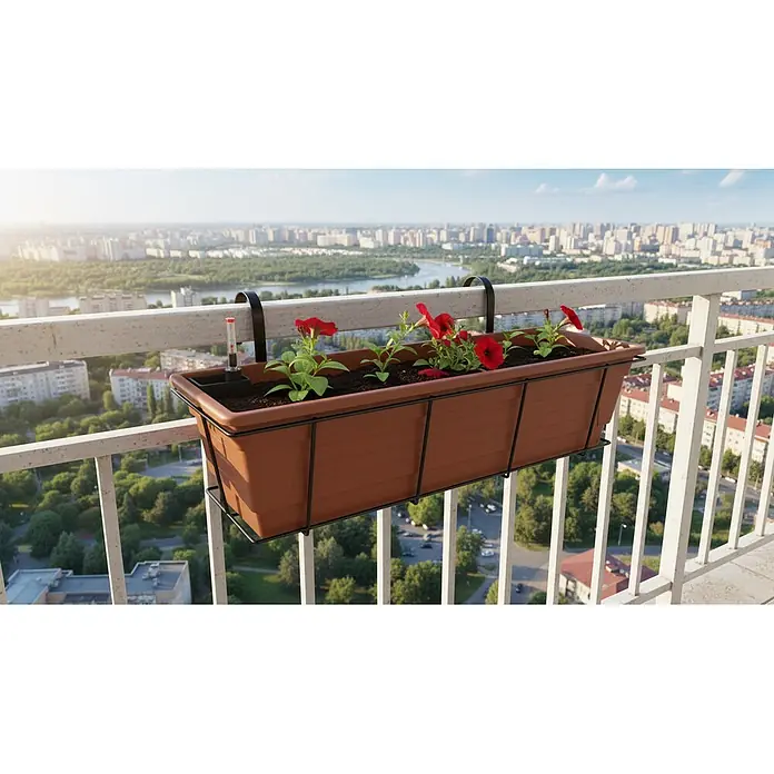 Plastard Pflanzkasten 3er Set 80 cm selbstwässernd Hydroeinsatz & Metallkorb - Außenmaß (L x B x H): 80 x 21 x 17 cm, Kunststoff, Terrakotta - Brauner Balkon-Pflanzkasten mit schwarzen Halterungen, roten Blumen und Feuchtigkeitsmesser an einem Balkongeländer vor Stadtkulisse.