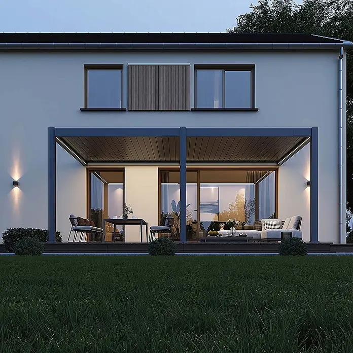 Weide Pergola E-Deluxe Plus Elektrisch für Wandmontage Aluminium 4 x 6 m Anthrazit - B x T: 600 x 400 cm, Farbe Gestell: Sandpapier FinishAnthrazit / RAL Farbcode 7024, Aluminium - Moderne dunkelgraue Pergola am Haus, die einen beleuchteten Ess- und Loungebereich im Freien in der Dämmerung überdacht.