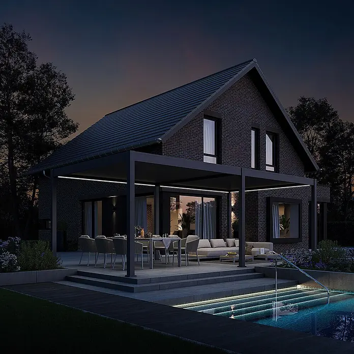 Weide Pergola Deluxe freistehend 3,6 x 7,2 m Anthrazit Aluminium - Farbe Gestell: Sandpapier FinishAnthrazit / RAL Farbcode 7024, Aluminium - Moderne, dunkle Pergola mit integrierter Beleuchtung über einer Terrasse mit Ess- und Lounge-Bereich neben einem beleuchteten Pool.