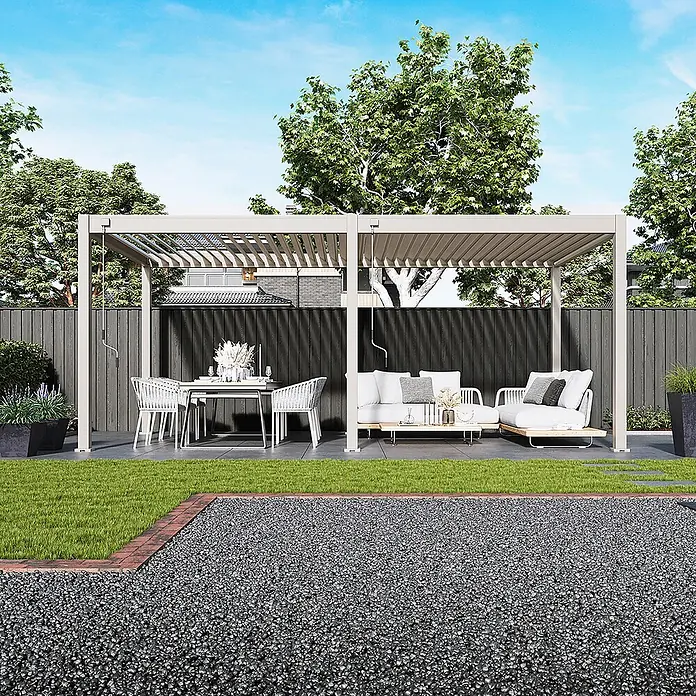 Weide Pergola Deluxe freistehend 3 x 6 m Ivory-Sand Aluminium - B x T: 600 x 300 cm, Farbe Gestell: Sandpapier FinishIvory Sand / RAL Farbcode 7024, Aluminium - Hellfarbene Metallpergola über einem Outdoor-Ess- und Lounge-Bereich im Garten.