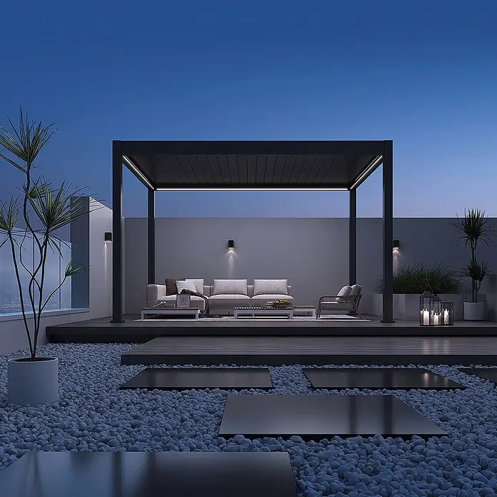 Weide Pergola Deluxe freistehend 3,6 x 4 m Anthrazit Aluminium - Farbe Gestell: Sandpapier FinishAnthrazit / RAL Farbcode 7024, Aluminium - Moderne dunkelgraue Metall-Pergola auf einer Dachterrasse in der Dämmerung, die einen Lounge-Bereich mit integrierter LED-Beleuchtung schützt.