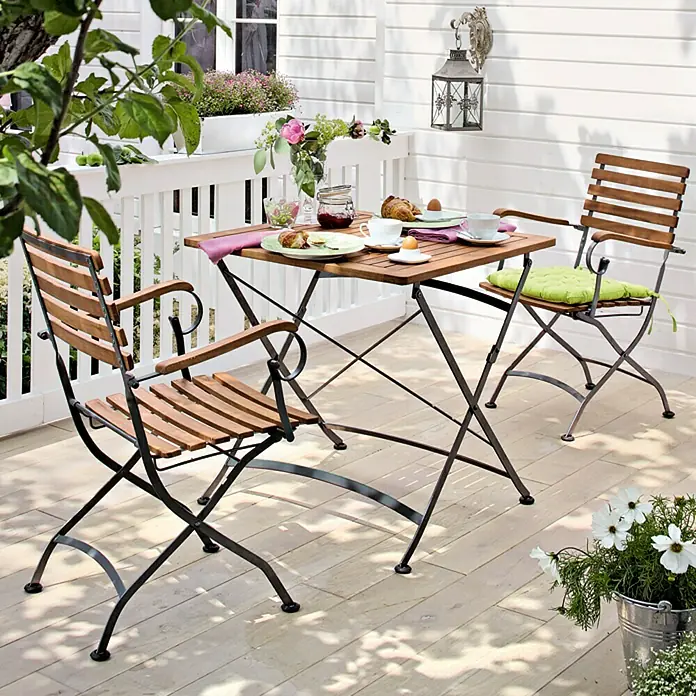 Sunfun Moni Gartenstuhl - Mit Armlehnen, Akazie, Klappbar, Schwarz, Naturbraun, B x T x H: 57 x 55 x 88 cm - Einladende Gartenszene mit Holztisch und zwei passenden Stühlen, ideal für entspannte Stunden im Freien.