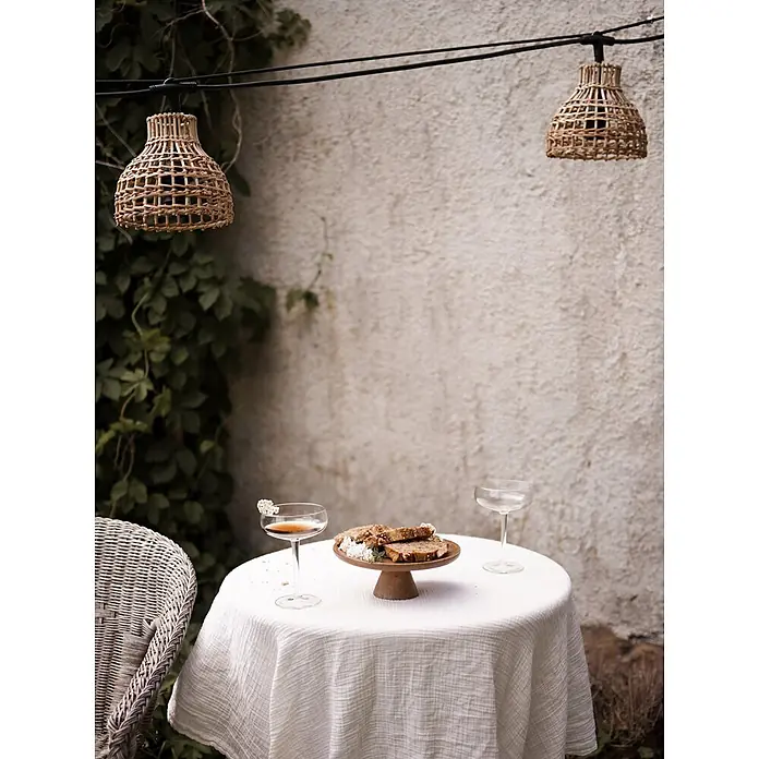 PR Home LED-Lichterkette Sarah -  - Geflochtene Rattan-Lichterkette beleuchtet einen Esstisch im Freien.