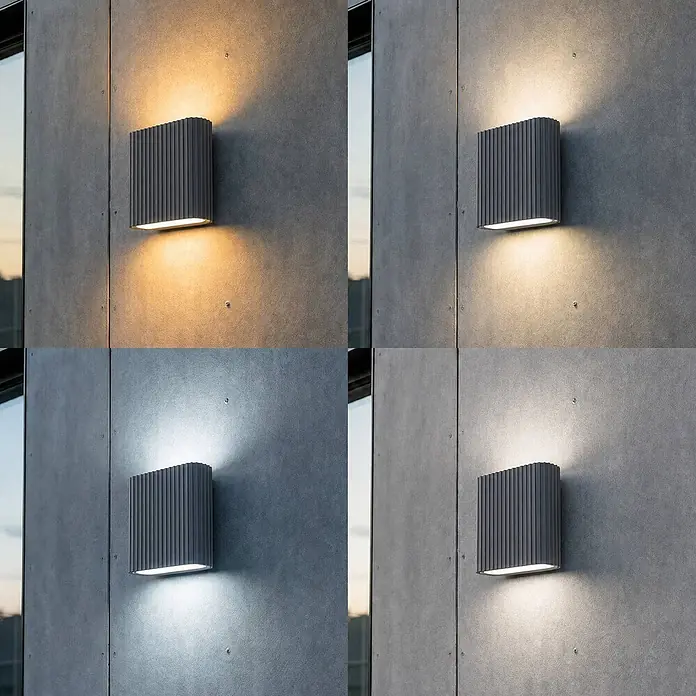 Lucande Außenwandleuchte Raija - 7,5 x 18 x 19 cm, alu / grau / zink, IP54 - Rechteckige graue gerippte Außenwandleuchte wirft warmes bis kaltweißes Licht nach oben und unten an Betonwand.