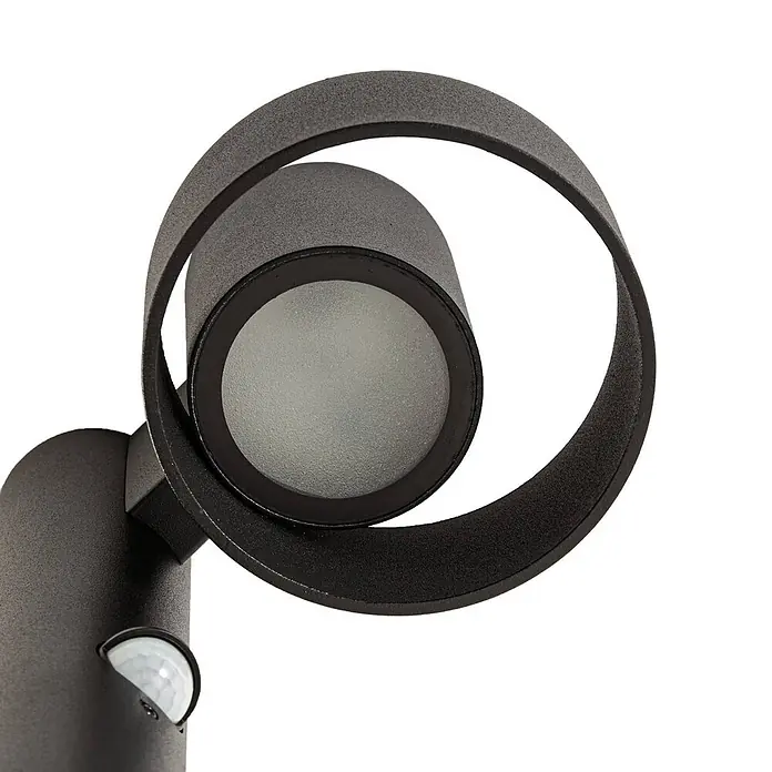 Lucande LED Wegeleuchte in schwarz matt, mit Bewegungsmelder, Gartenlampe -  - Dunkelgraue Außenwandleuchte mit strukturierter Oberfläche, runder Lichtquelle, spiralförmigem Arm und Bewegungssensor.