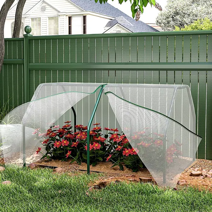 Outsunny Gewächshaus - 99 x 71 cm, Material Seitenwand: Kunststoff, 0,3 mm, Dunkelgrau - Weißes Netz-Frühbeet mit grünem Saum, teilweise geöffnet, bedeckt rote Blumen im Garten.