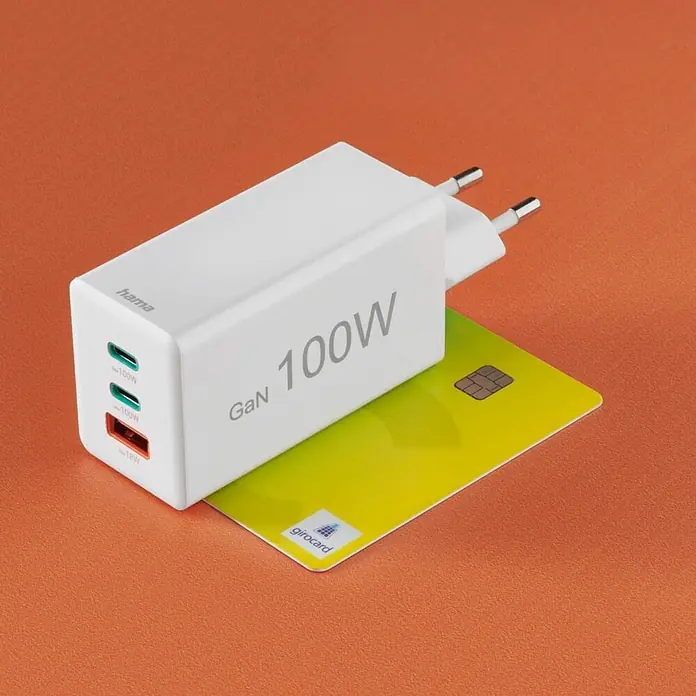 Hama Schnellladegerät 00201997 GaN 2x USB-C 1x USB-A Mini-Ladegerät PD 100 W - Weiß - Weißes Hama GaN 100W Ladegerät mit EU-Stecker und 3 Anschlüssen (100W, 100W, 18W) auf einer gelben girocard Kreditkarte.