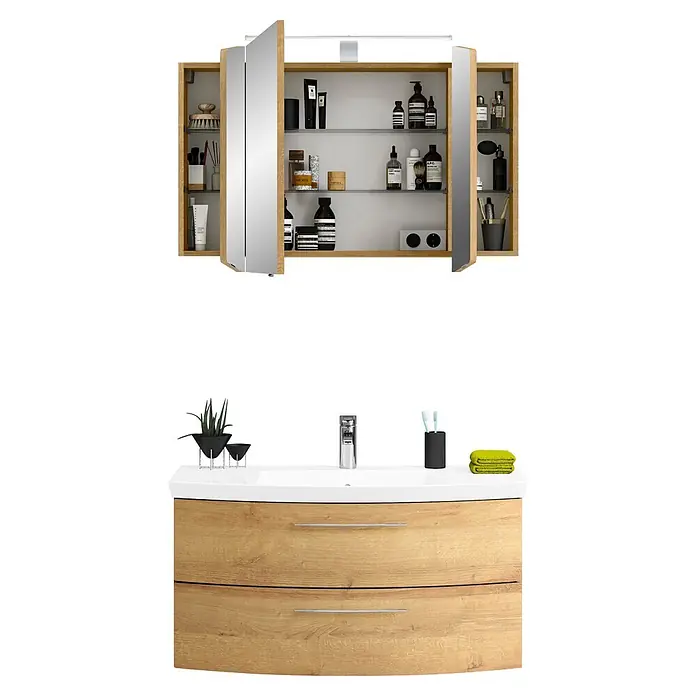 Pelipal Cassca Badmöbel-Set - Gesamtbreite Badmöbel: 101 cm, Riviera Eiche, Matt - Hölzerner Badezimmerschrank mit weißem Waschbecken und passendem Spiegelschrank. Mit Chromarmatur, Pflanze, Toilettenartikeln und Handtüchern.