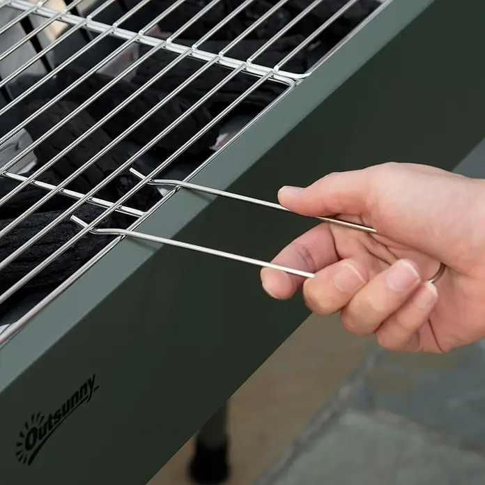 Outsunny Holzkohlegrill - Dunkelgrün - Hand hebt mit Metallwerkzeug das silberne Rost von einem olivgrünen Outsunny Holzkohlegrill mit schwarzer Kohle.