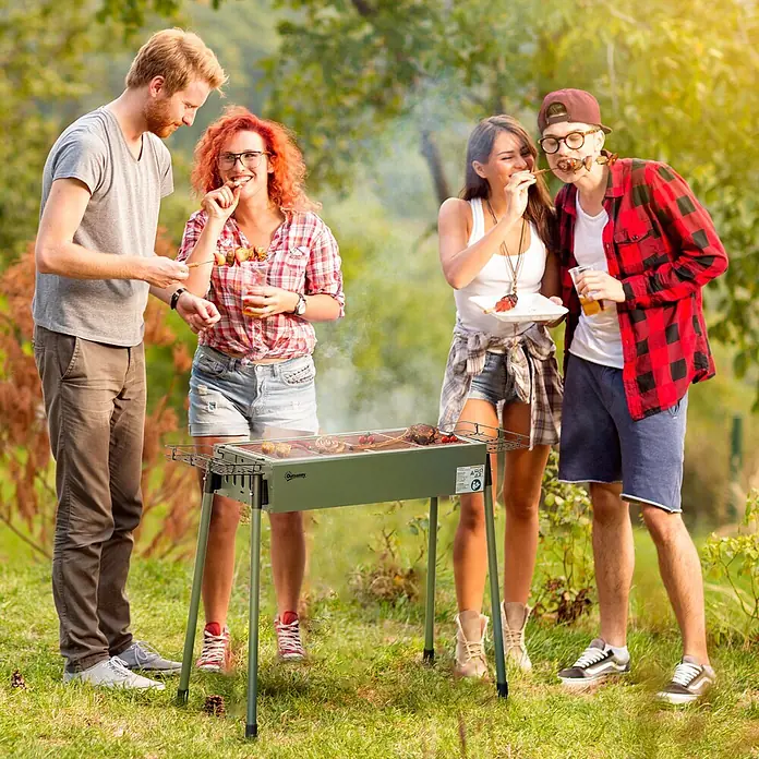 Outsunny Holzkohlegrill - Dunkelgrün - Ein dunkelgrüner tragbarer BBQ-Grill wird von Freunden im Freien benutzt, um Speisen auf Spießen zu garen.