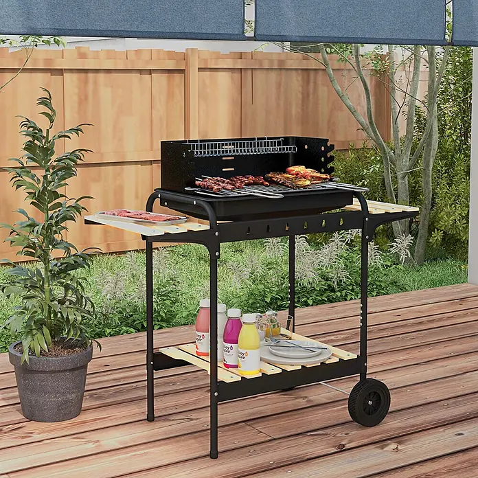 Outsunny Holzkohlegrill - Durchmesser Grillfläche: 58 cm, Schwarz - Schwarzer Metall-BBQ-Grill mit Holzablagen, Speisen auf dem Rost und Zubehör auf den Ablagen, auf einer Holzterrasse zum Grillen im Freien.