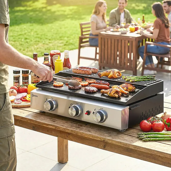 Outsunny Gasgrill - Anzahl Brenner: 3 Stk. - Eine silberne und schwarze Outsunny Gasgrillplatte, die im Freien verschiedene Speisen zubereitet, während eine Person grillt und andere im Hintergrund essen.