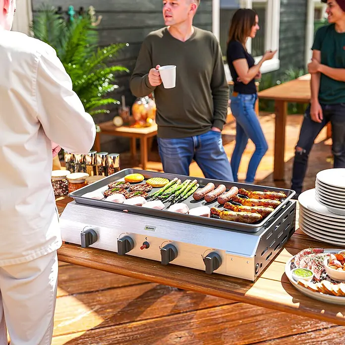 Outsunny Gasgrill - Anzahl Brenner: 4 Stk. - Silberne Gas-Grillplatte, die verschiedene Speisen kocht, draußen auf einem Holztisch bei einer Party verwendet.