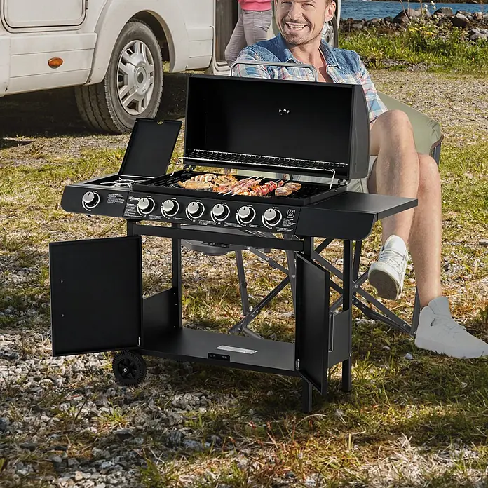 Outsunny Gasgrill - Anzahl Brenner: 1 Stk. - Schwarzer Gasgrill mit kochendem Essen, im Freien von einem Mann neben einem Wohnmobil benutzt. Er verfügt über mehrere Brenner und Staufächer.
