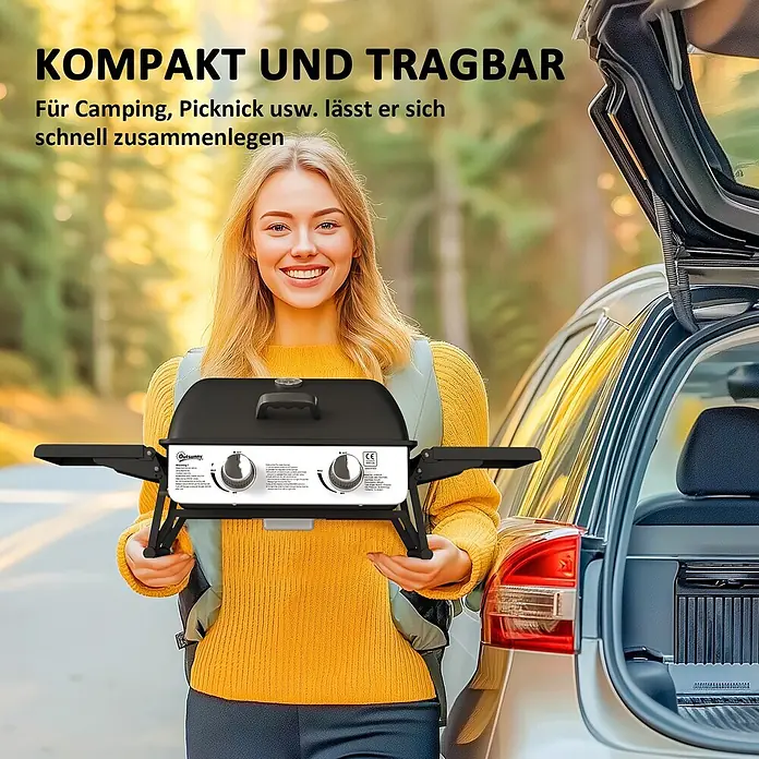 Outsunny Gasgrill - Anzahl Brenner: 2 Stk. - Frau hält einen kompakten schwarz-weißen tragbaren Gasgrill, bereit für Camping oder Picknick neben einem Auto.