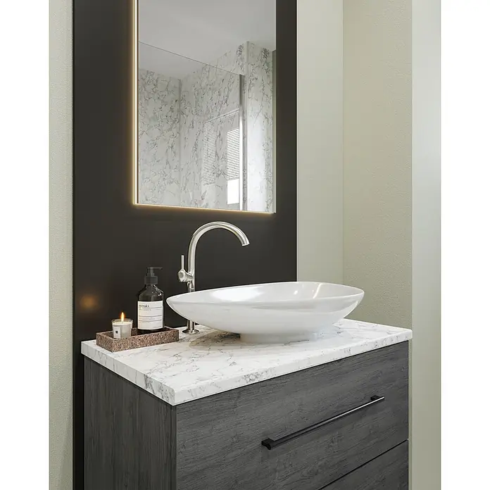 Wetwall Waschtischplatte Vanity HPL - 150 x 60 x 2,8 cm, White Marble - Ein moderner Badwaschtisch mit weißer Aufsatzschale, Chromarmatur, Marmorplatte, dunklem Holzschrank und hinterleuchtetem Spiegel, mit Badeöl und Kerze.