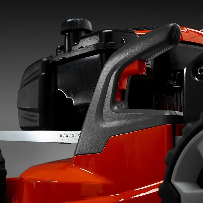 Husqvarna Benzin-Rasenmäher LC253S - 2.750 W, 166 cm³, Schnittbreite: 530 mm - Nahaufnahme eines Rasenmähers: schwarzer Motor, orangefarbenes Gehäuse, grauer Griff und Schnitthöhenverstellhebel mit Einstellungen 3 bis 6.