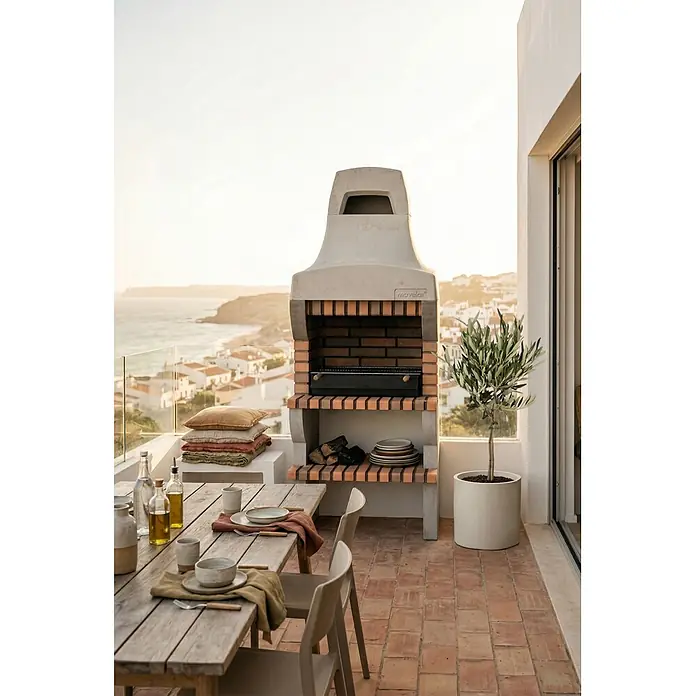Movelar Palermo Holzkohlegrill - Grillfläche (B x T): 69,5 x 35 cm, Grau - Ein Gartengrill aus Beton und Ziegelsteinen auf einer Terrasse, bereit zum Kochen, mit Ablagen für Holz und Teller.