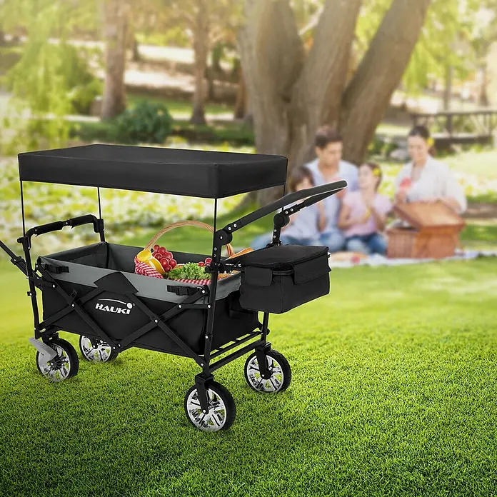 Hauki Bollerwagen Handwagen Transportwagen faltbar klappbar mit Bremse Dach und Tasche - L x B x H: 196 x 56 x 99 cm - Schwarzer Faltwagen mit Verdeck, beladen mit Picknickartikeln.