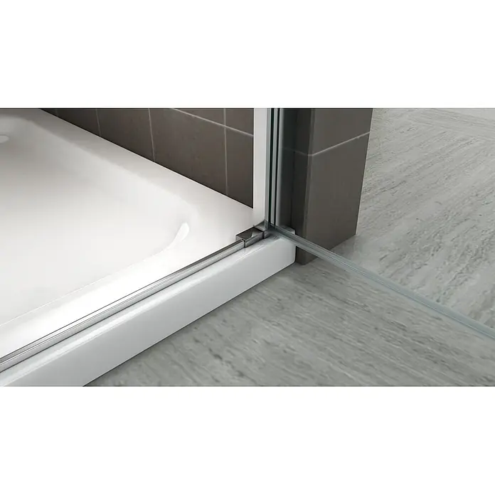 i-flair Dusch-Pendeltür NM74 - 74 x 195 cm, Silber, Beschichtet, Glasstärke: 6 mm - Nahaufnahme des unteren Rands einer Duschkabinentür mit klarer Dichtung, Glas und Chromprofil auf einer weißen Duschwanne.