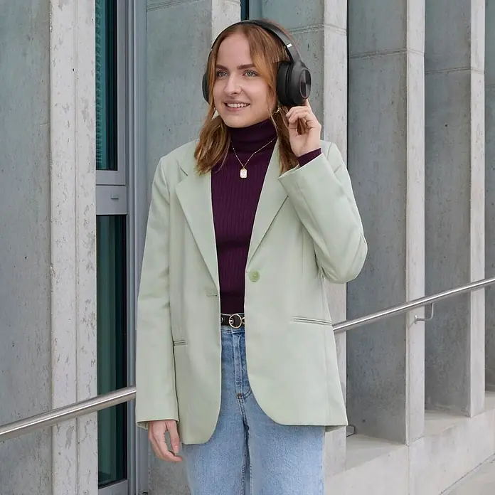 Hama Kopfhörer Spirit Calypso III On Ear Bluetooth - Schwarz - Schwarze Over-Ear-Kopfhörer an einer Frau im Freien.