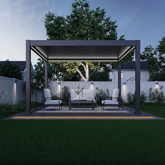 Weide Pergola E-Deluxe Plus Elektrisch freistehend Aluminium 3 x 4 m Anthrazit - B x T: 400 x 300 cm, Farbe Gestell: Sandpapier FinishAnthrazit / RAL Farbcode 7024, Aluminium - Moderne dunkelgraue Aluminium-Pergola mit integrierter LED-Beleuchtung, die einen beleuchteten Wohnbereich im Freien auf einem Deck mit Möbeln schafft.