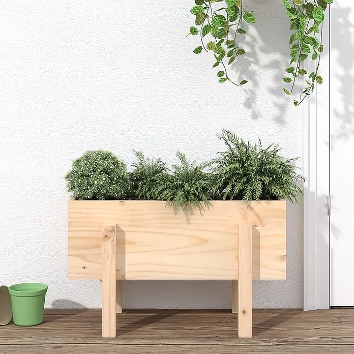 Furnicato Hochbeet - 30 x 62 x 38 cm, Holz, Natürliche Kiefer - Helles Holz-Pflanzgefäß mit üppigen grünen Pflanzen, auf einer Holzterrasse stehend.