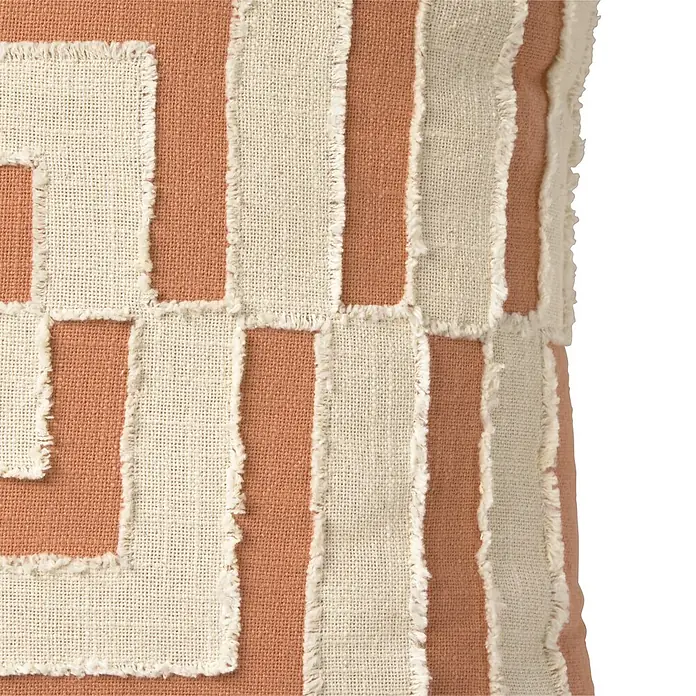 Cojín Arinka - 45 x 45 cm, Teja, Cuadrado - Textil con parches de tela cruda deshilachados creando un patrón geométrico sobre fondo terracota. Textura rústica.