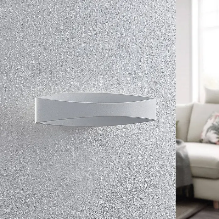 Arcchio Wandleuchte Jelle - weiß / opal, weiß / opal - Weiße moderne LED-Wandleuchte mit geschwungenem, überlappendem Oval-Design, an einer strukturierten Wand montiert.