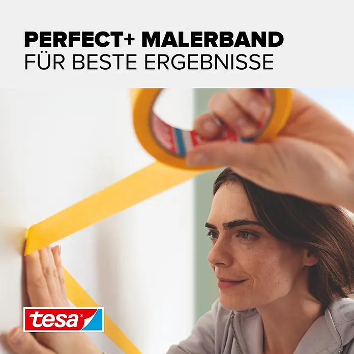 Tesa Malerband Perfect+ - 50 m x 30 mm - Gelbes tesa Malerkrepp wird von einer Frau auf eine weiße Wand geklebt, um präzise Farbkanten zu schaffen.