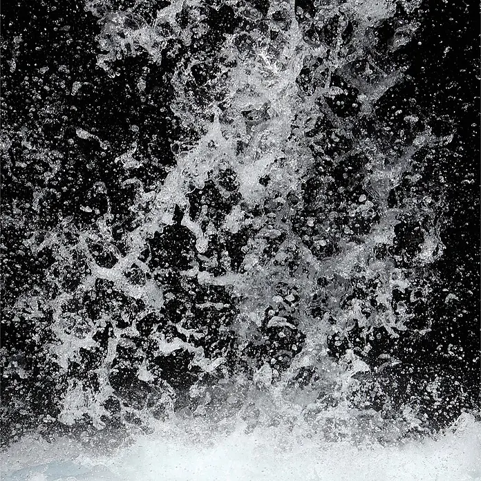 SanDesign Acryl-Verbundplatte - 100 x 250 cm, Waterfall - Weißes Wasser spritzt und sprüht vor schwarzem Hintergrund.