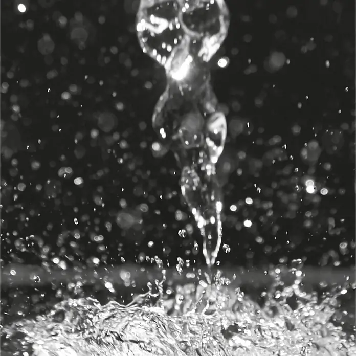 SanDesign Acryl-Verbundplatte - 100 x 250 cm, Waterdrops - Klares Wasser fällt und spritzt, erzeugt Wellen und Tropfen vor dunklem Hintergrund.