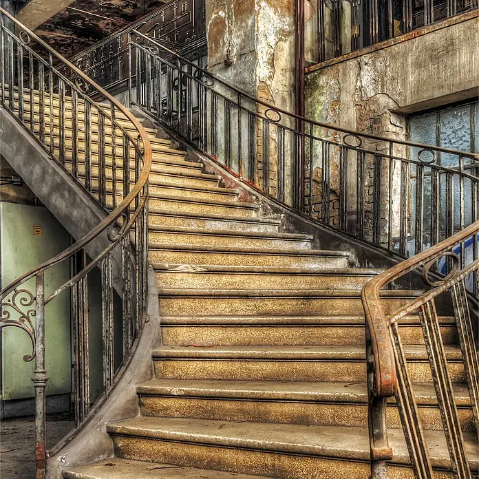 SanDesign Acryl-Verbundplatte - 100 x 250 cm, Lost Place Staircase - Große, abgenutzte Betontreppe mit verzierten, rostigen Metallgeländern.