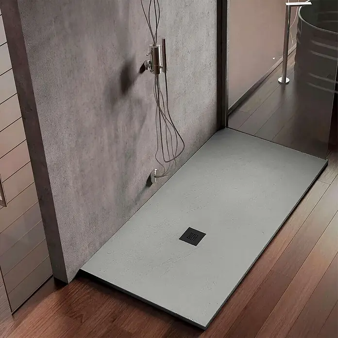 Poalgi Duschwanne Hos's HL - L x B: 130 x 70 cm, Verbundwerkstoff, Hellgrau - Flache graue Duschwanne mit schwarzem Ablauf, nahtlos in einen Duschbereich mit Betonwand und Holzfußboden integriert.