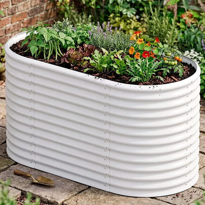 Vitavia Hochbeet Terra 858 - 162 x 82 x 85,8 cm, Zincalume®, Blank - Weißes Hochbeet aus Wellblech, gefüllt mit Kräutern und Gemüse, auf Steinplatten im Freien.