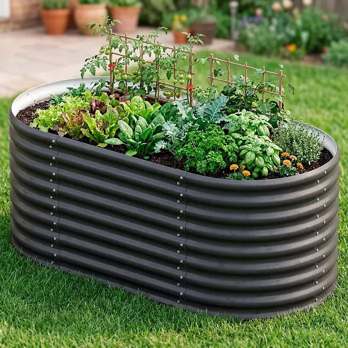 Vitavia Hochbeet Terra 630 - 162 x 82 x 63 cm, Zincalume®, Schwarz - Ein ovales, dunkelgraues Hochbeet aus Wellblech, gefüllt mit Gemüse und Kräutern, auf grünem Rasen.