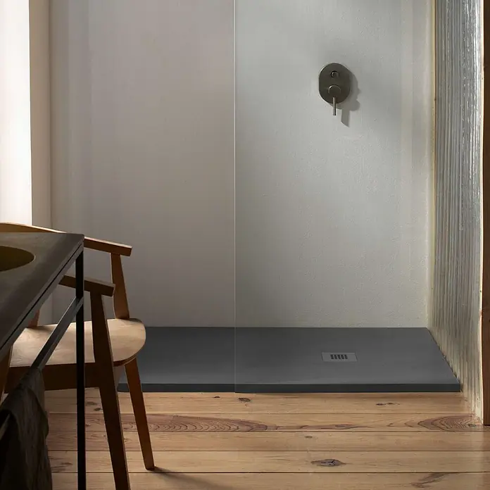 Poalgi Duschwanne Arena - L x B: 140 x 90 cm, Verbundwerkstoff, Antracita - Dunkelgraue, flache Duschwanne in einem modernen Badezimmer mit Holzboden, neben einem Duschmischer.