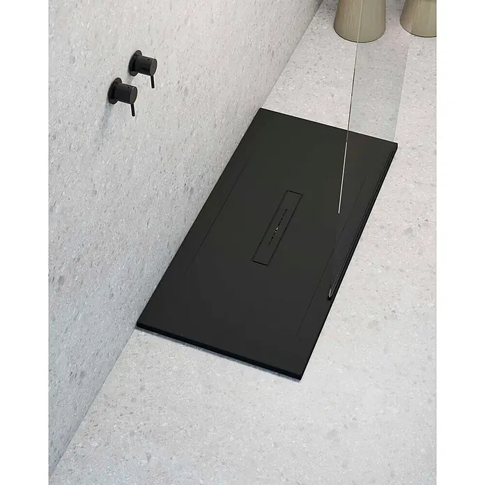 Poalgi Duschwanne Clay - L x B: 120 x 90 cm, Verbundwerkstoff, Schwarz - Mattschwarze Duschwanne mit integriertem Linienablauf, auf hellgrauen Sprenkel-Fliesen, mit schwarzen Wandarmaturen.