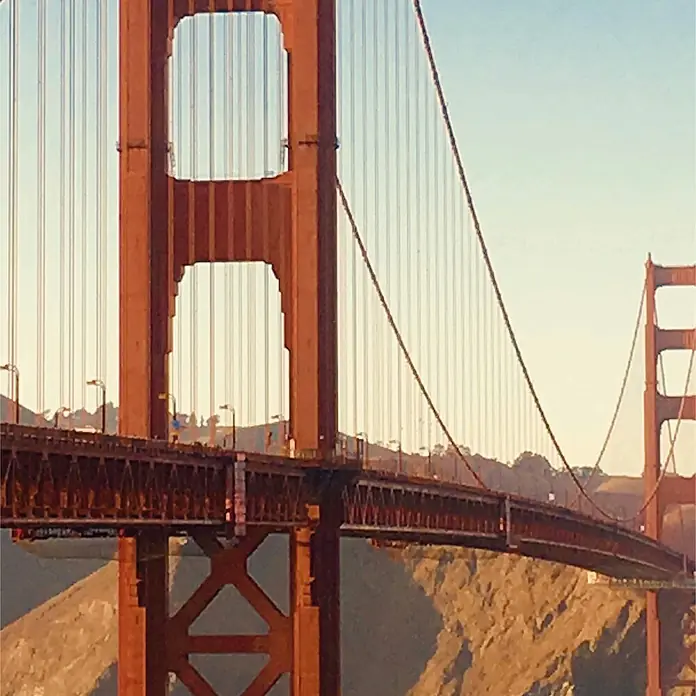 SanDesign Acryl-Verbundplatte - 100 x 250 cm, Golden Gate - Nahaufnahme der ikonischen rot-orangen Golden Gate Bridge, mit Turm, Kabeln und einem Brückendeck-Abschnitt.