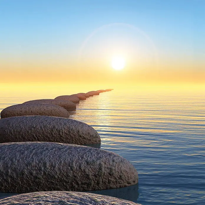 SanDesign Alu-Verbundplatte - 100 x 250 cm, Sunrise - Ein Pfad aus glatten, dunklen Trittsteinen führt über ruhiges Wasser zu einem leuchtenden Sonnenuntergang.