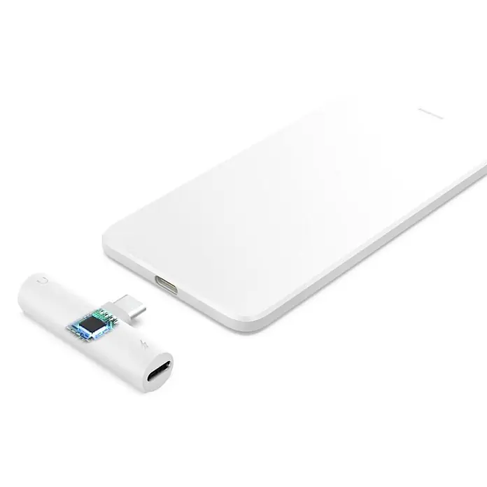 Hama Audio-Adapter 00201723 Audio-Adapter USB-C - 35-mm-Klinke USB-C PD inkl. Ladefunktion -  - Weißer USB-C Splitter mit Audio- und Ladeanschlüssen, neben einem weißen Smartphone.