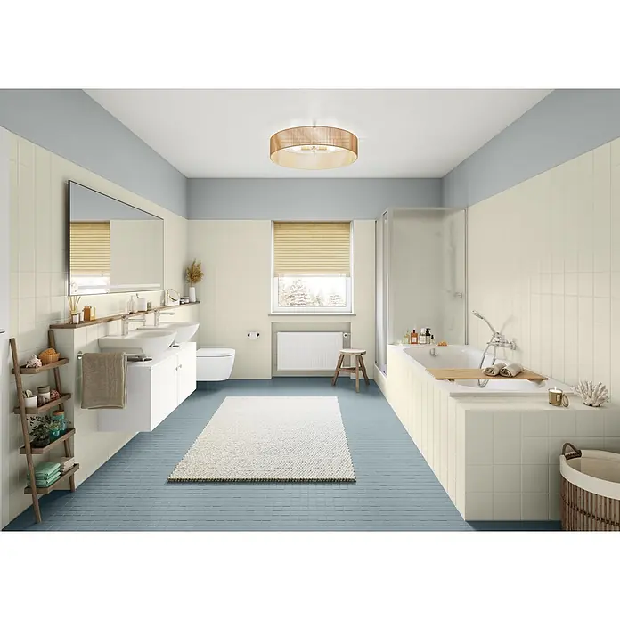 Alpina Wandfarbe Bad & Küche Sturmwolke - Grau, Matt, 2,5 l - Modernes Badezimmer mit cremefarbenen Wandfliesen, hellblauen Bodenfliesen und einem blauen oberen Wandbereich, mit Doppelwaschtisch und Badewanne.