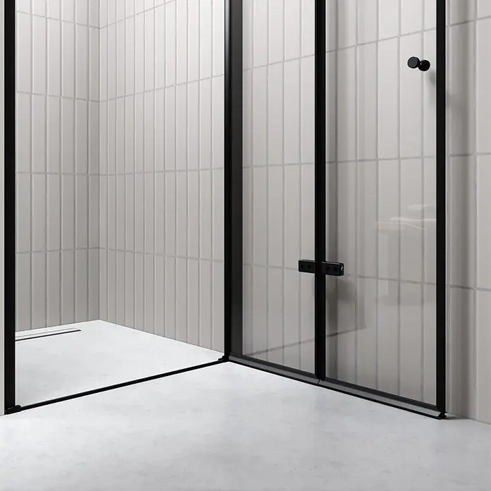 i-flair Dusch-Falttür DT822CB84 - Beschichtet, Schwarz, Glasstärke: 6 mm - Schwarz gerahmte Duschkabine aus Klarglas in modernem Bad mit vertikalen Fliesen und Ablaufrinne.